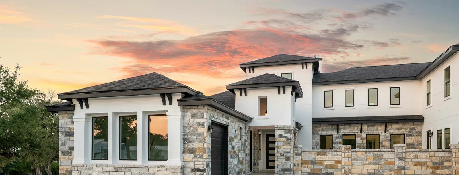 Vivienda moderna de lujo con acentos en piedra al atardecer