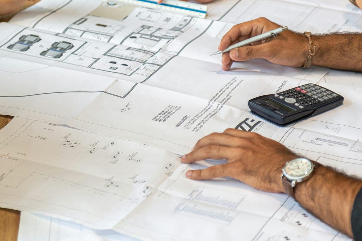Profesionales revisando planos arquitectónicos y definiendo un proyecto