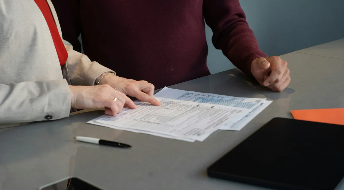 Dos profesionales revisando documentos y planos sobre una mesa
