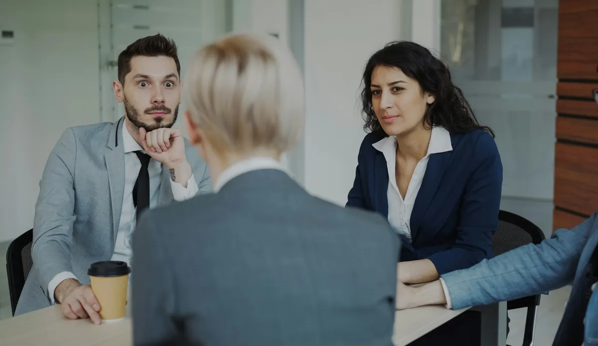 Equipo conversando alrededor de una mesa en una oficina moderna